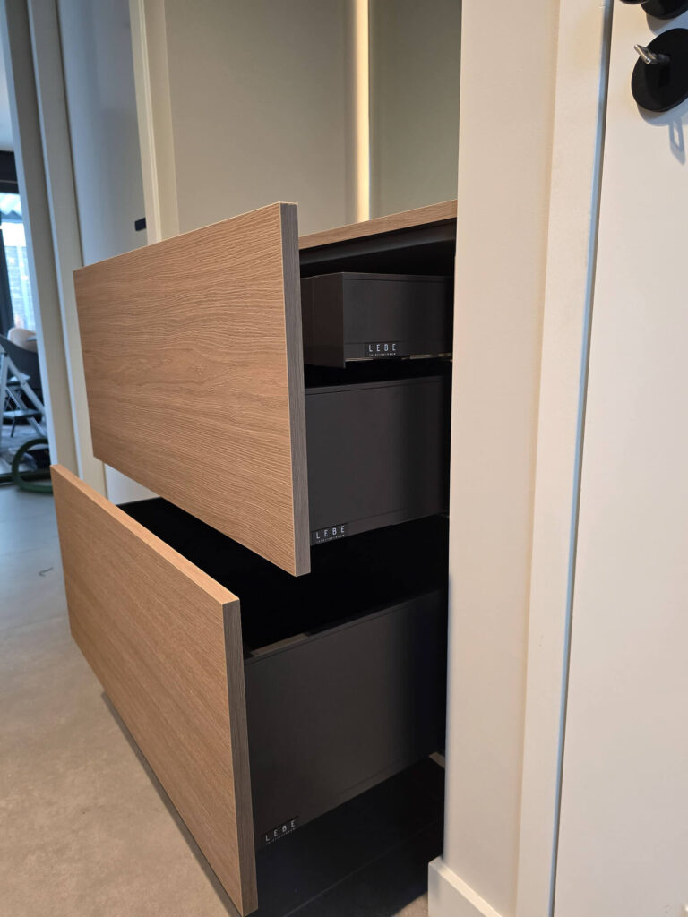 Moderne woonkamerinrichting in Roermond met op maat gemaakt TV meubel, wandkast, verlichting en gashaard.