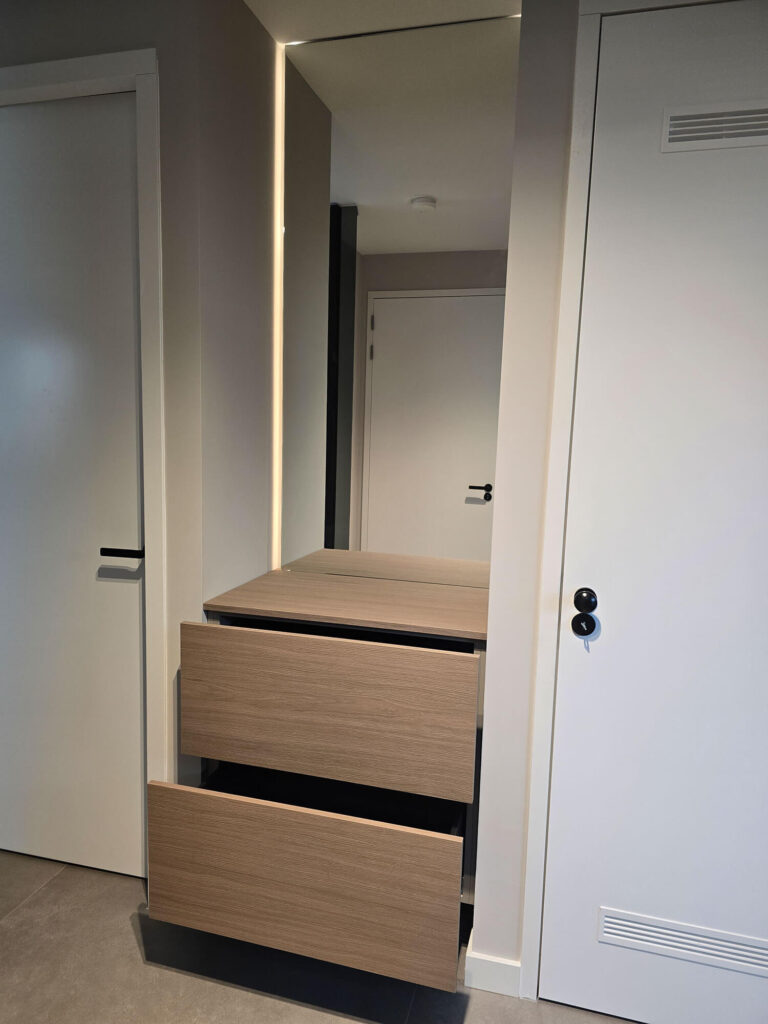 Moderne woonkamerinrichting in Roermond met op maat gemaakt TV meubel, wandkast, verlichting en gashaard.