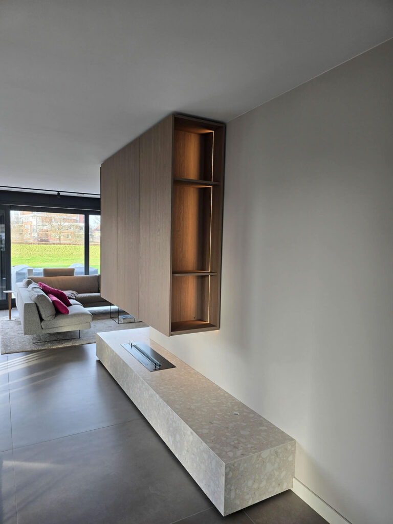 Moderne woonkamerinrichting in Roermond met op maat gemaakt TV meubel, wandkast, verlichting en gashaard.